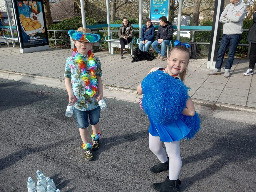 A boy and girl offering water to the Marathon participants