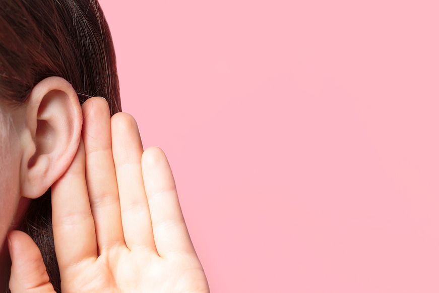 Female Listening Attentively With Palm To Her Ear