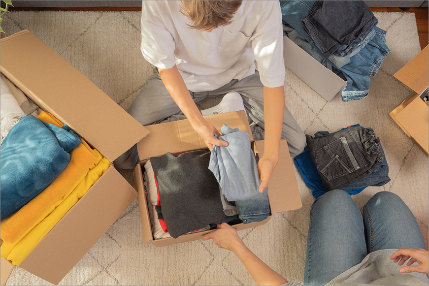 People packing clothing in boxes People packing clothing in boxes