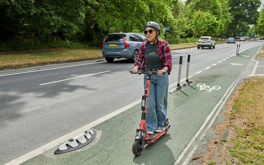Woman riding e-scooter in bike lane