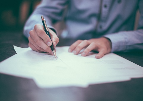 Man filling out form on pen and paper