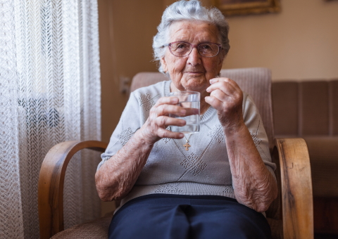 Elderly woman taking pill