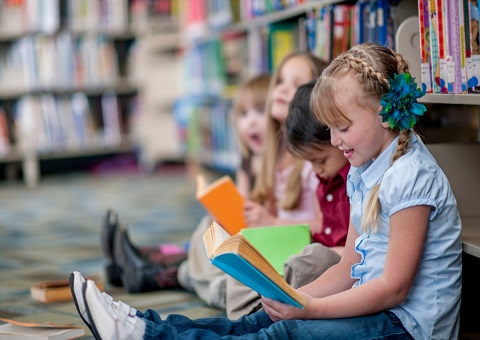 Children reading on library floor