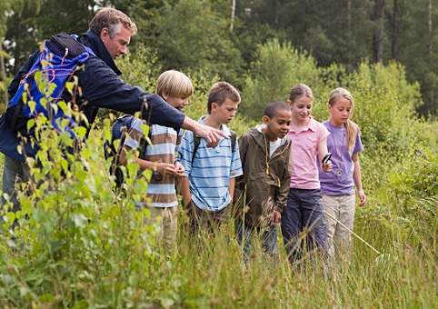 An adult and some children in grassland