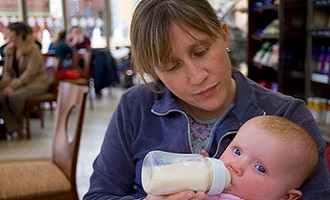 Woman bottle feeding baby