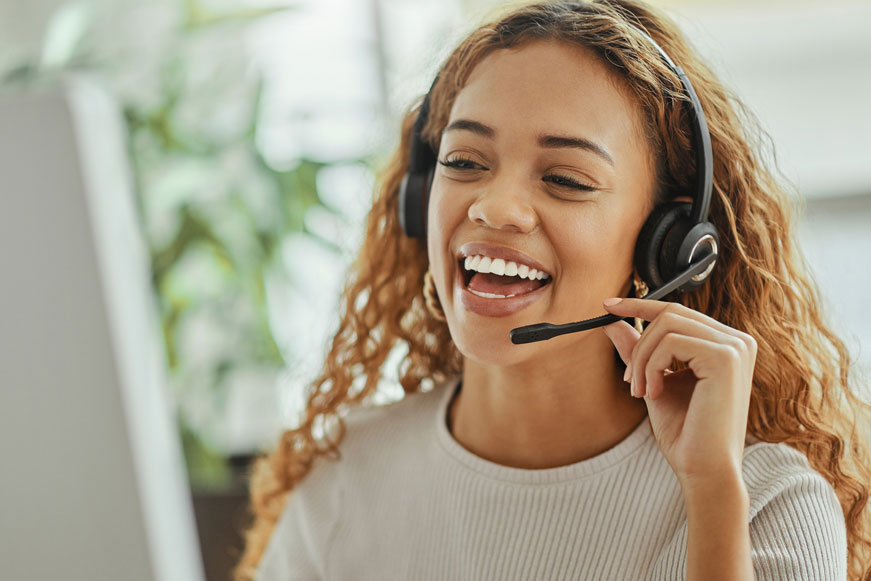 A happy woman taking a phone call using a headset A happy woman taking a phone call using a headset