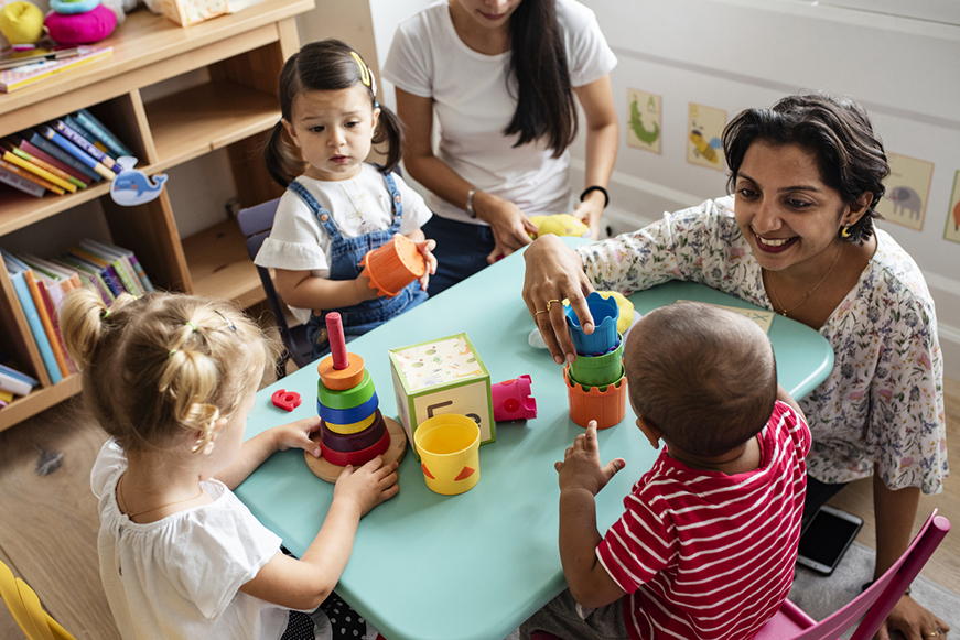 Children Playing At A Table At Childcare Children Playing At A Table At Childcare