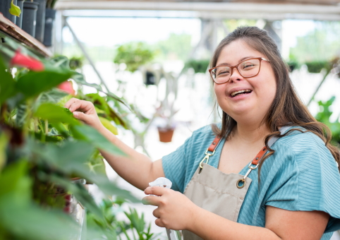 A girl with Down's Syndrome watering plants