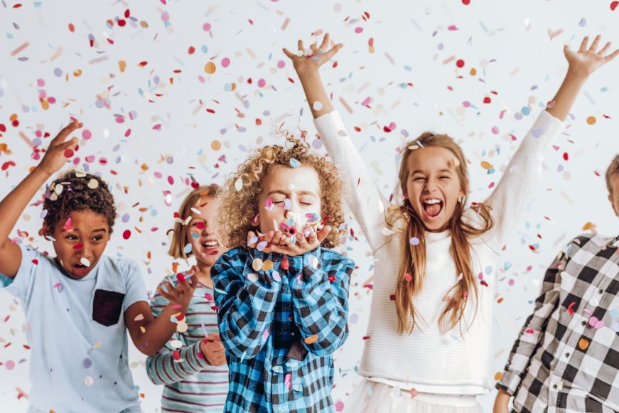 Five children celebrating in a shower of confetti