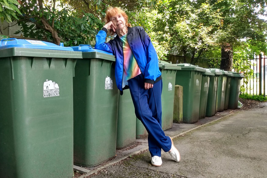 A woman leaning on a recycling bin A woman leaning on a recycling bin