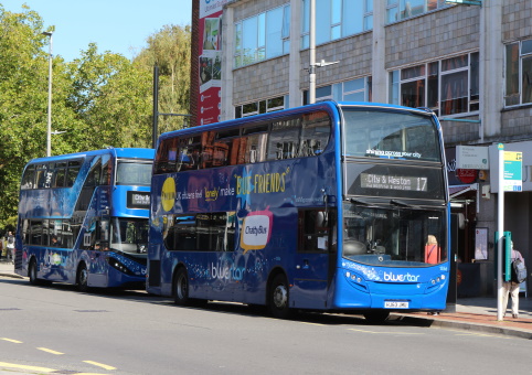 Buses, a cyclist and some pedestrians