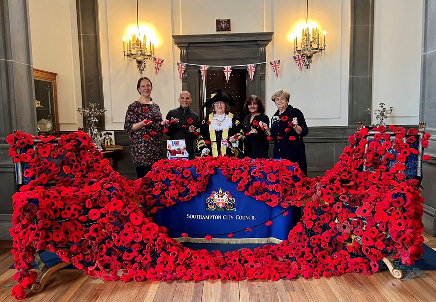 The Lord Mayor of Southampton and Woolston Library Volunteers pose with thousands of knitted poppies in the Mayors Parlour