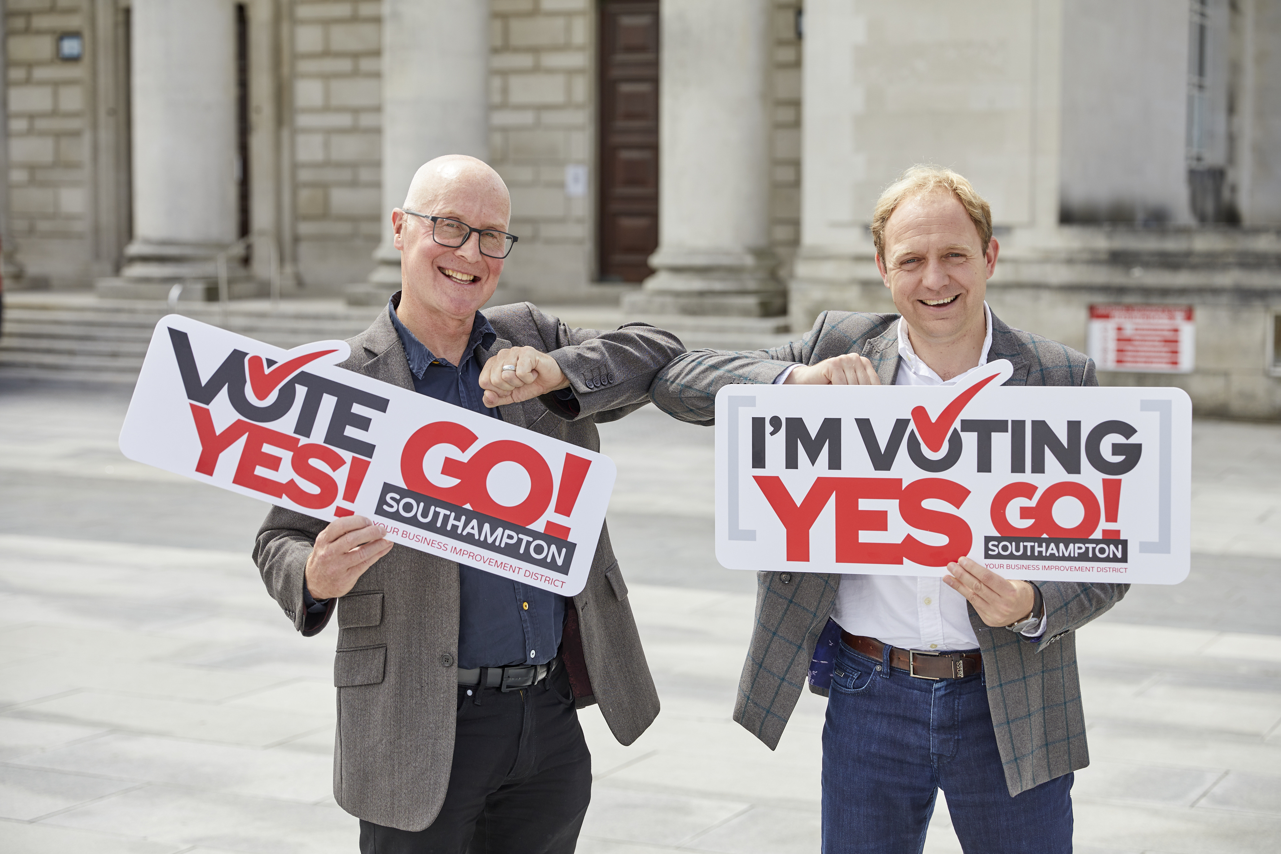 Giles Semper and Councillor Fitzhenry touching elbows and holding signs saying 'Vote Yes!' and 'Go! Southampton'