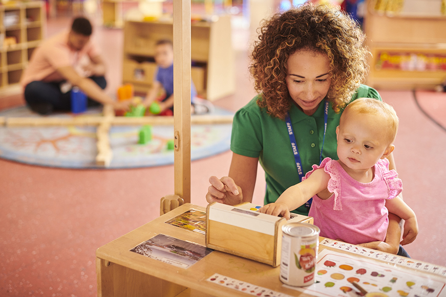 A woman holding a child at a day care centre A woman holding a child at a day care centre