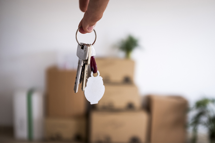 Several keys on a keyring held against a stack of boxes