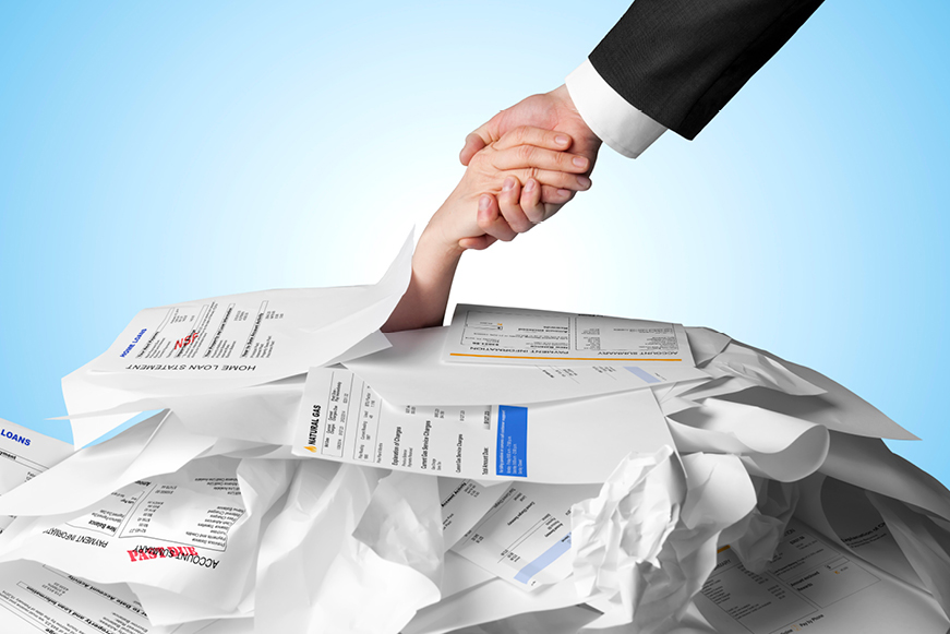 Someone pulling another person out of a pile of debt letters Someone pulling another person out of a pile of debt letters