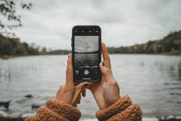 Person taking a picture of flooding on a phone